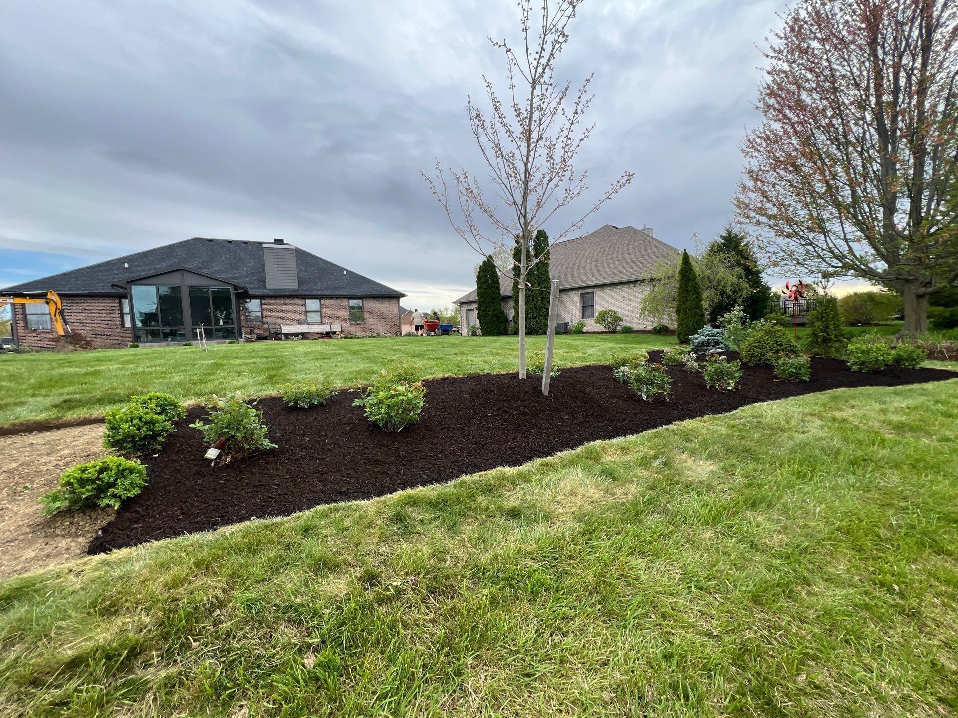 A large lush green lawn with a house in the background.