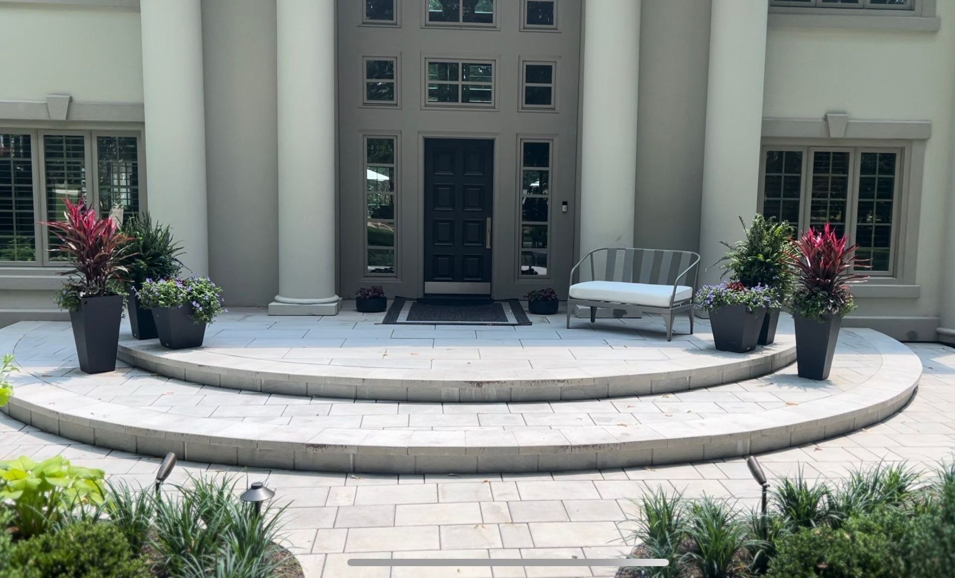 A large house with a circular patio in front of it.