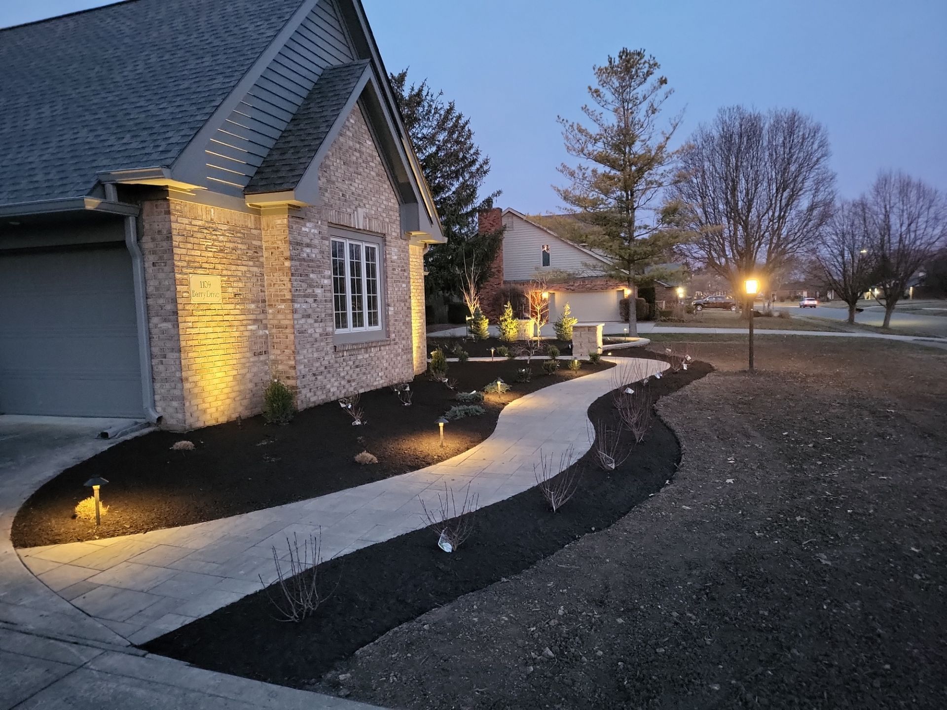 A house with a walkway leading to it is lit up at night