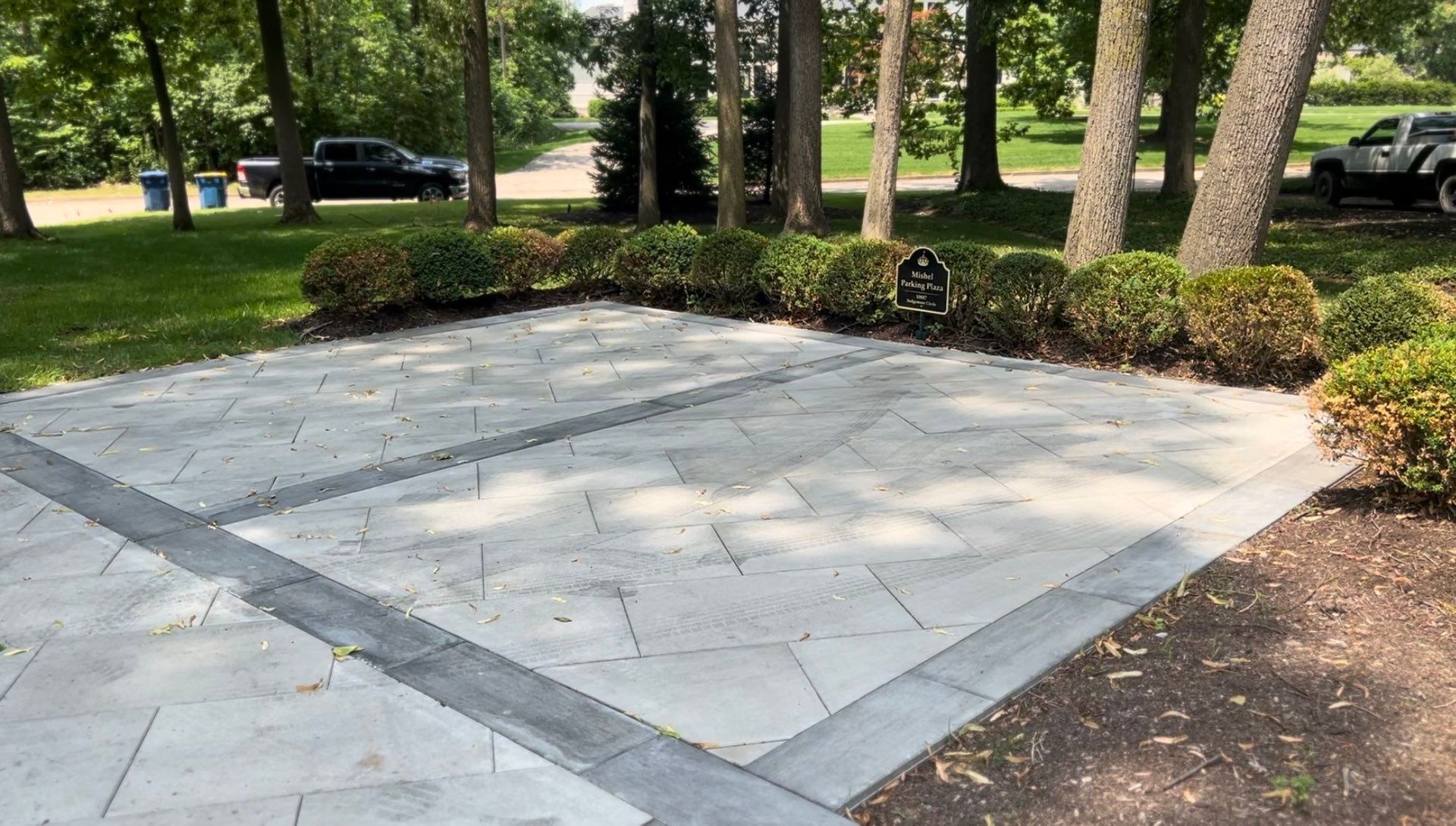 A concrete driveway in a park with trees in the background.