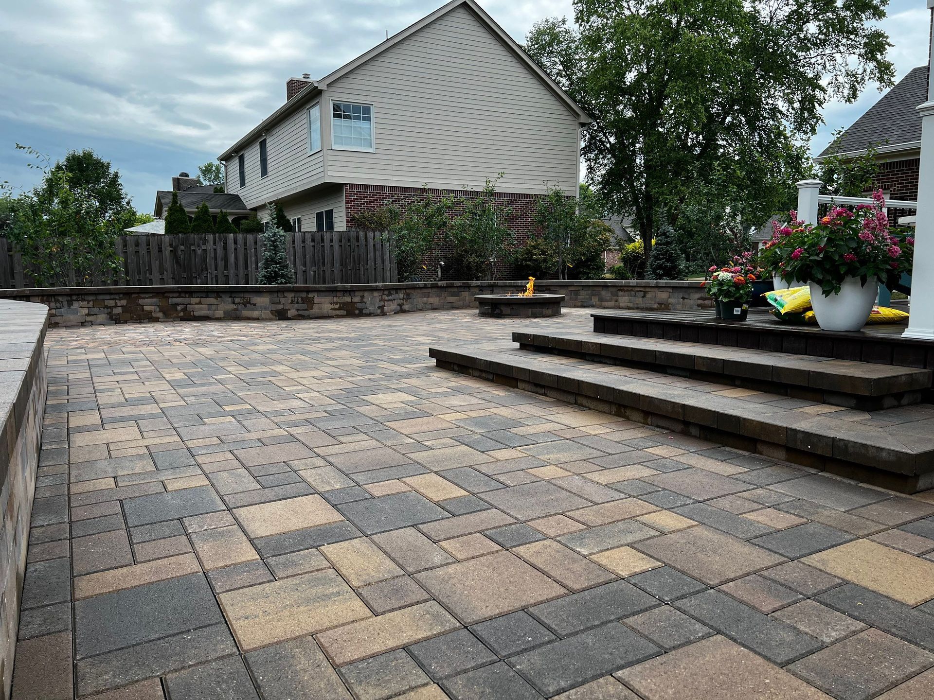 A patio with steps and a house in the background.