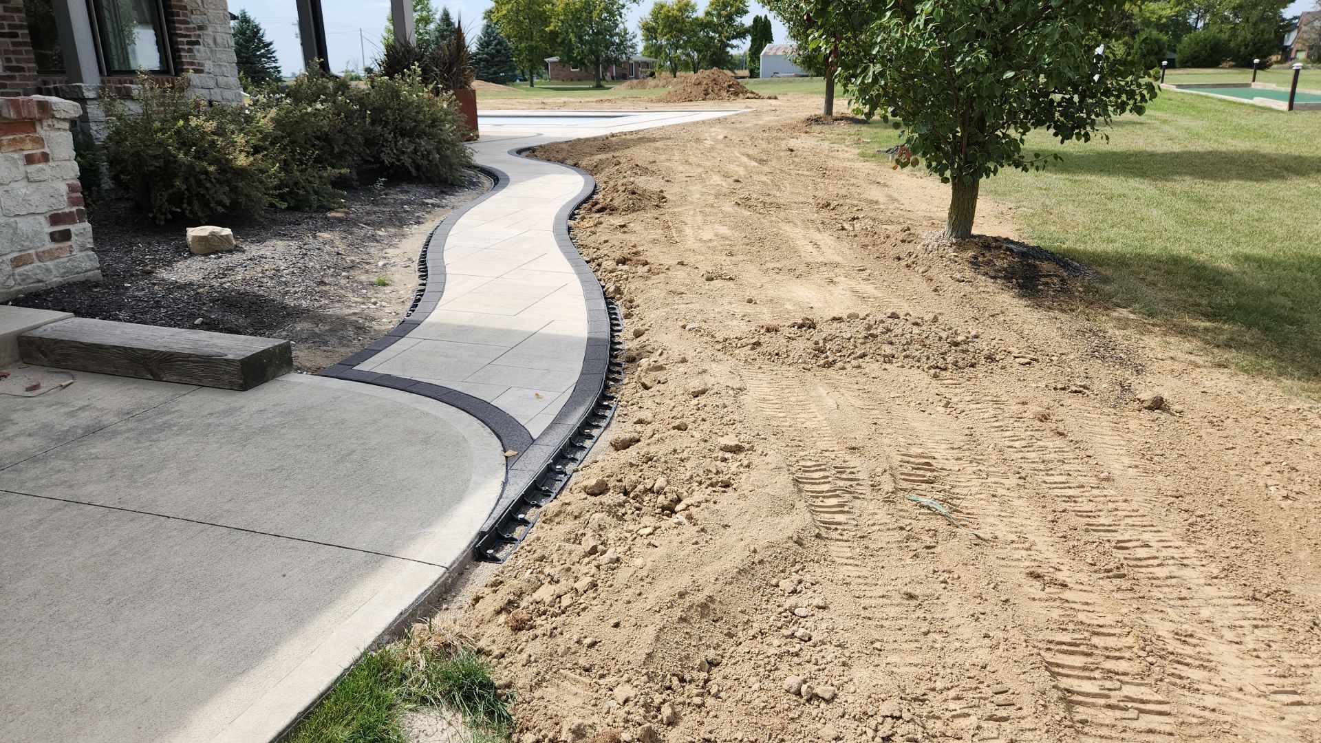 A concrete walkway is being built in front of a house.