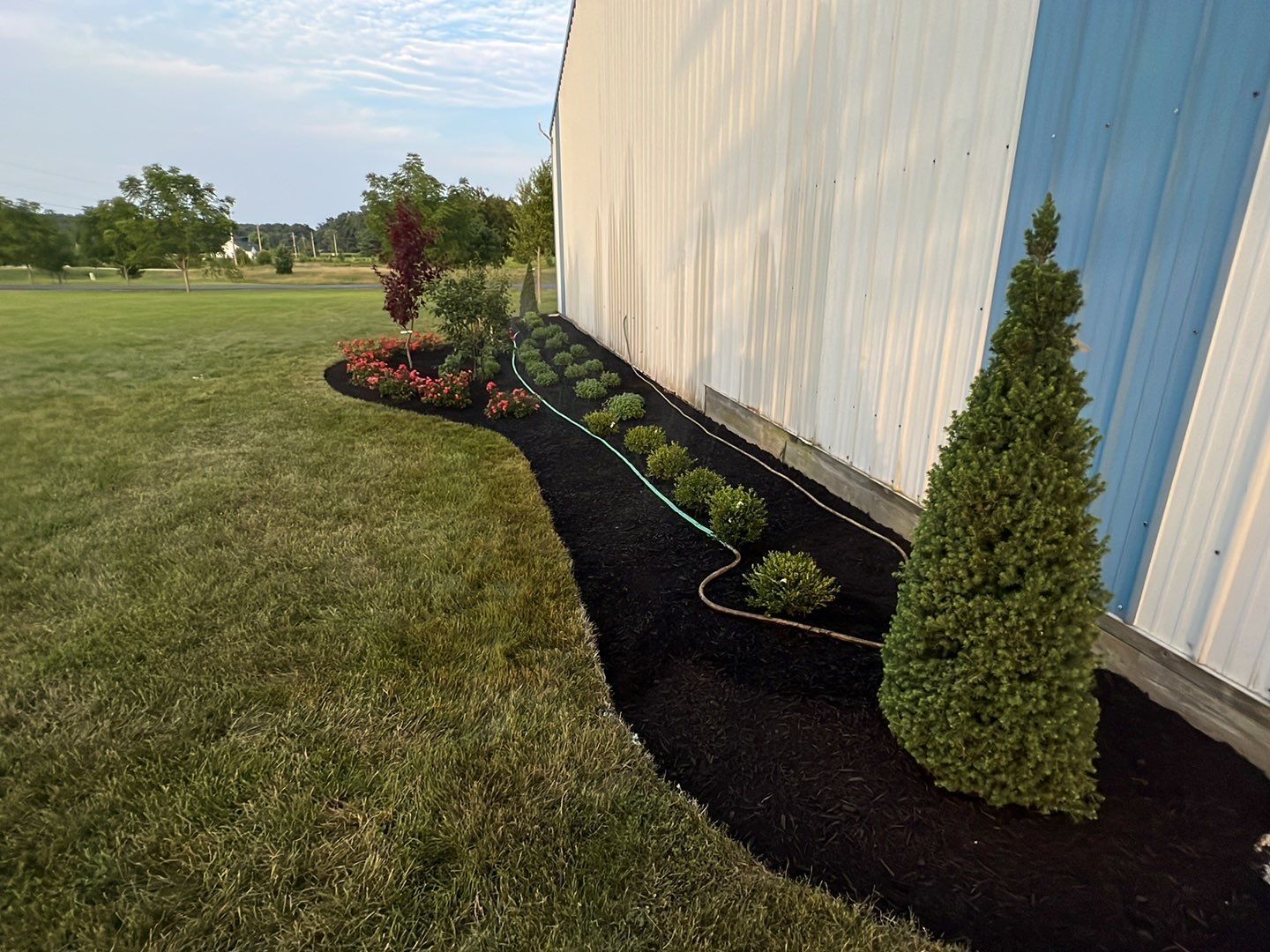 A white building with a lush green lawn in front of it.