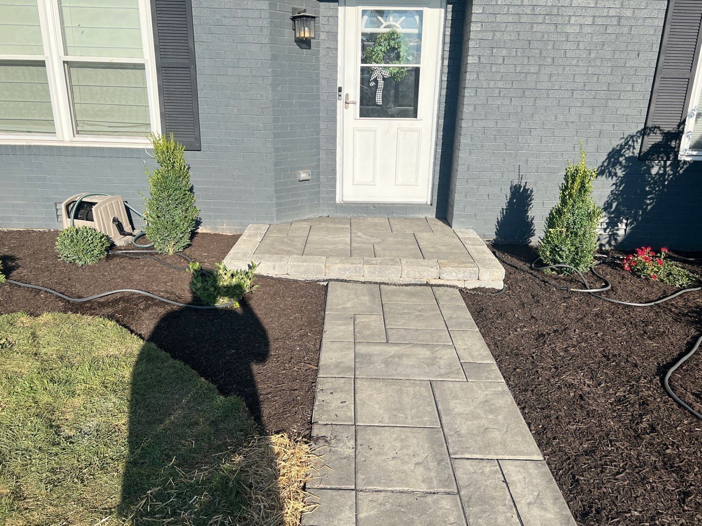 A brick house with a walkway leading to the front door.