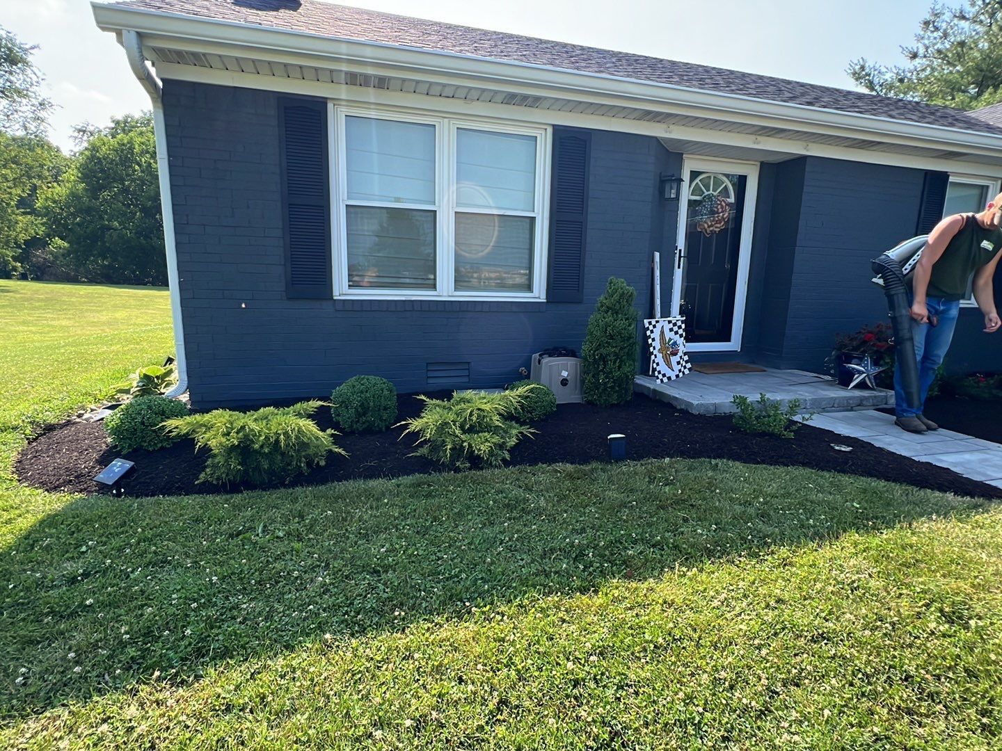 A couple of people are standing in front of a blue house.