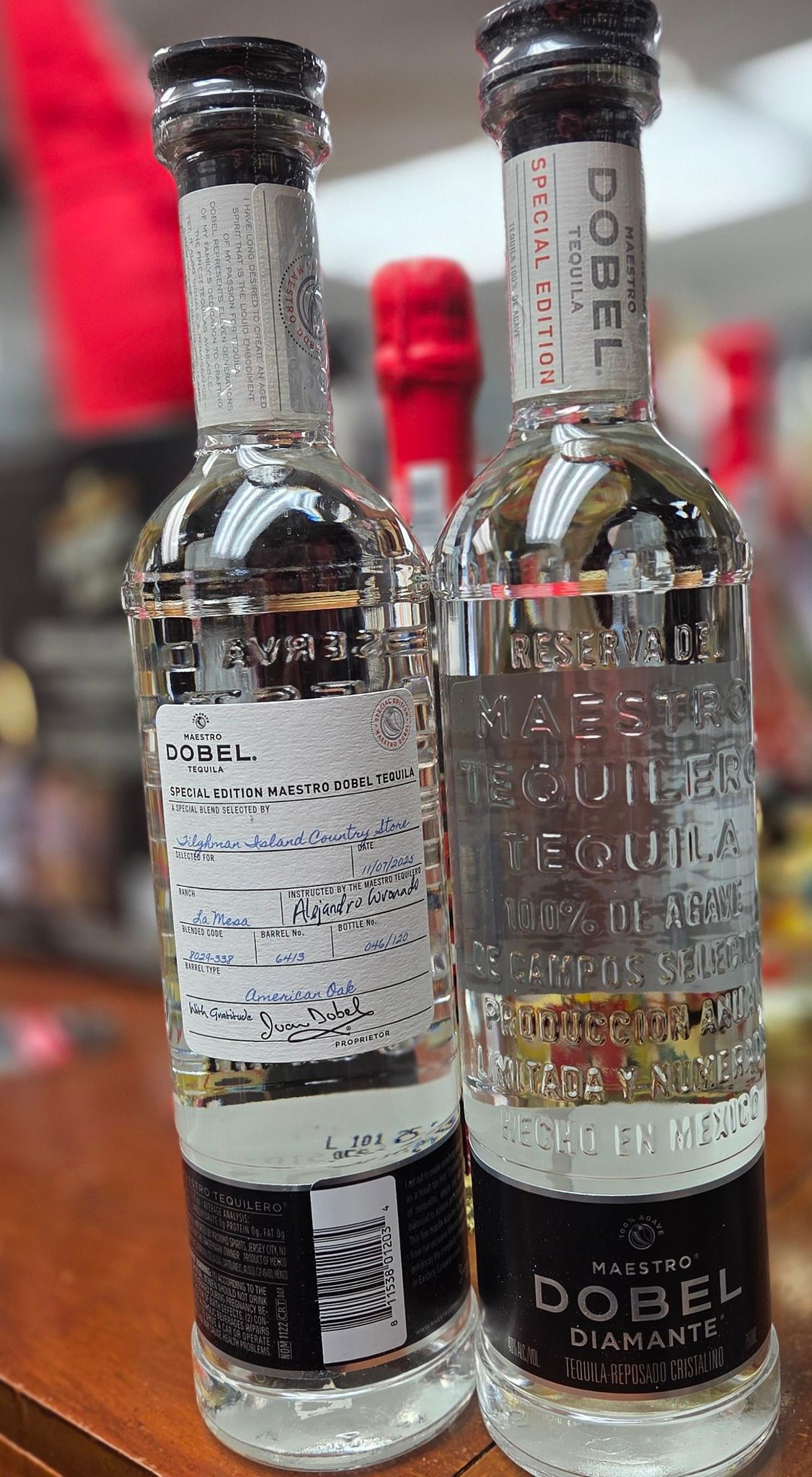 Two bottles of Maestro Dobel Diamante tequila standing on a wooden surface.