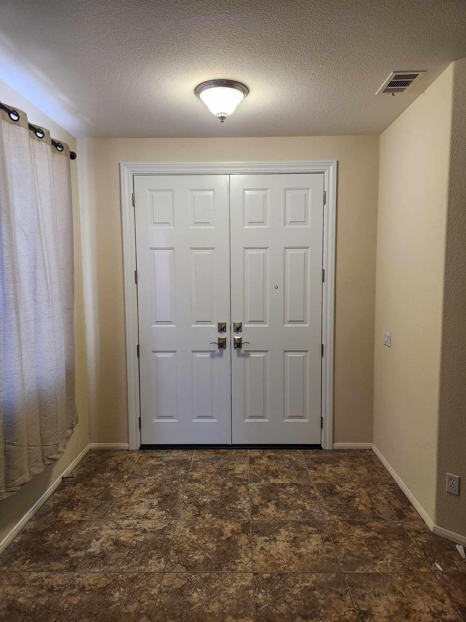 A hallway with two white doors and a brown carpet.