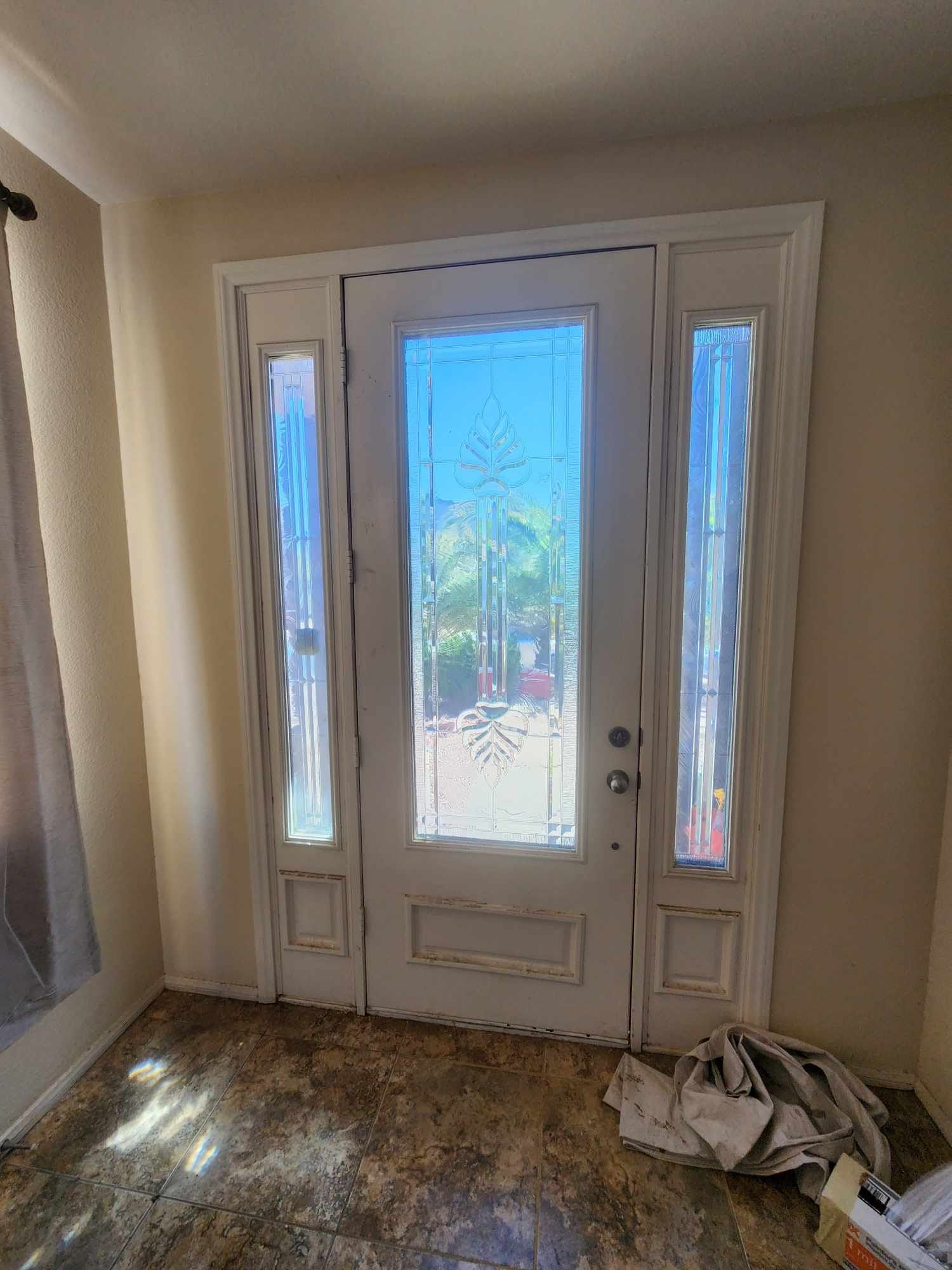 A white door with a stained glass window in a room.