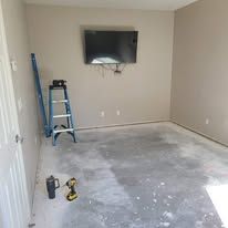 A room with a ladder and a flat screen tv on the wall.