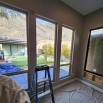 A room with a lot of windows and a ladder in it.