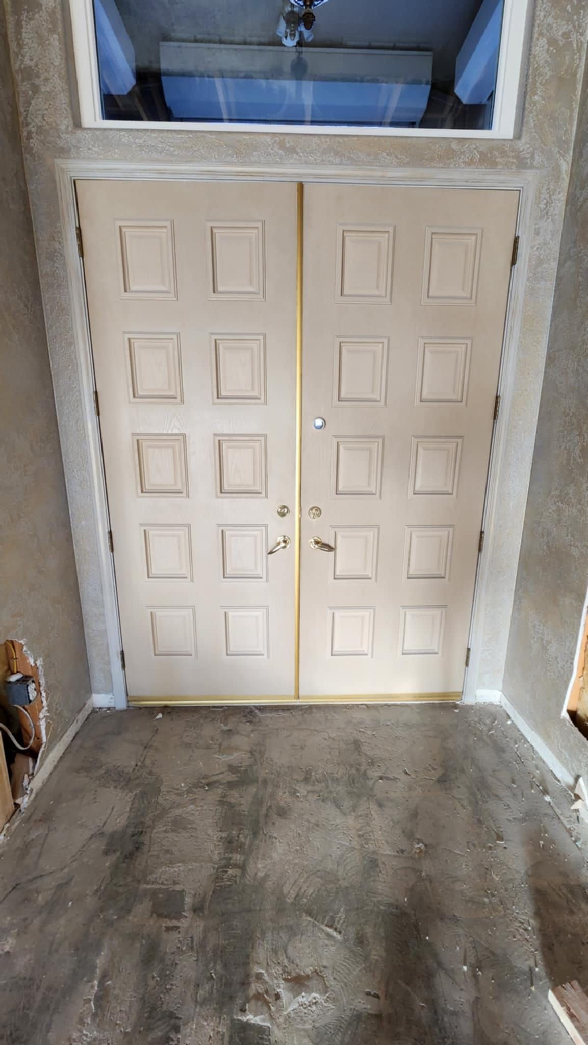 A pair of white doors leading into a room with a window.