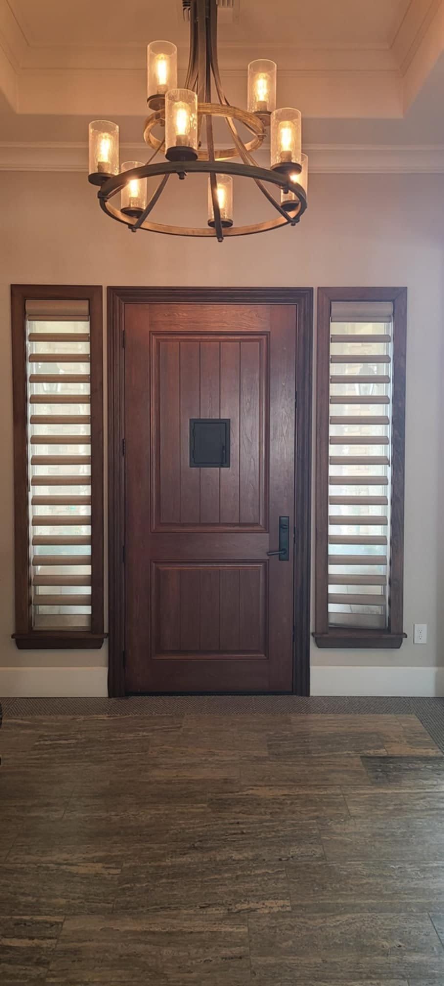 There is a chandelier hanging from the ceiling above the door.