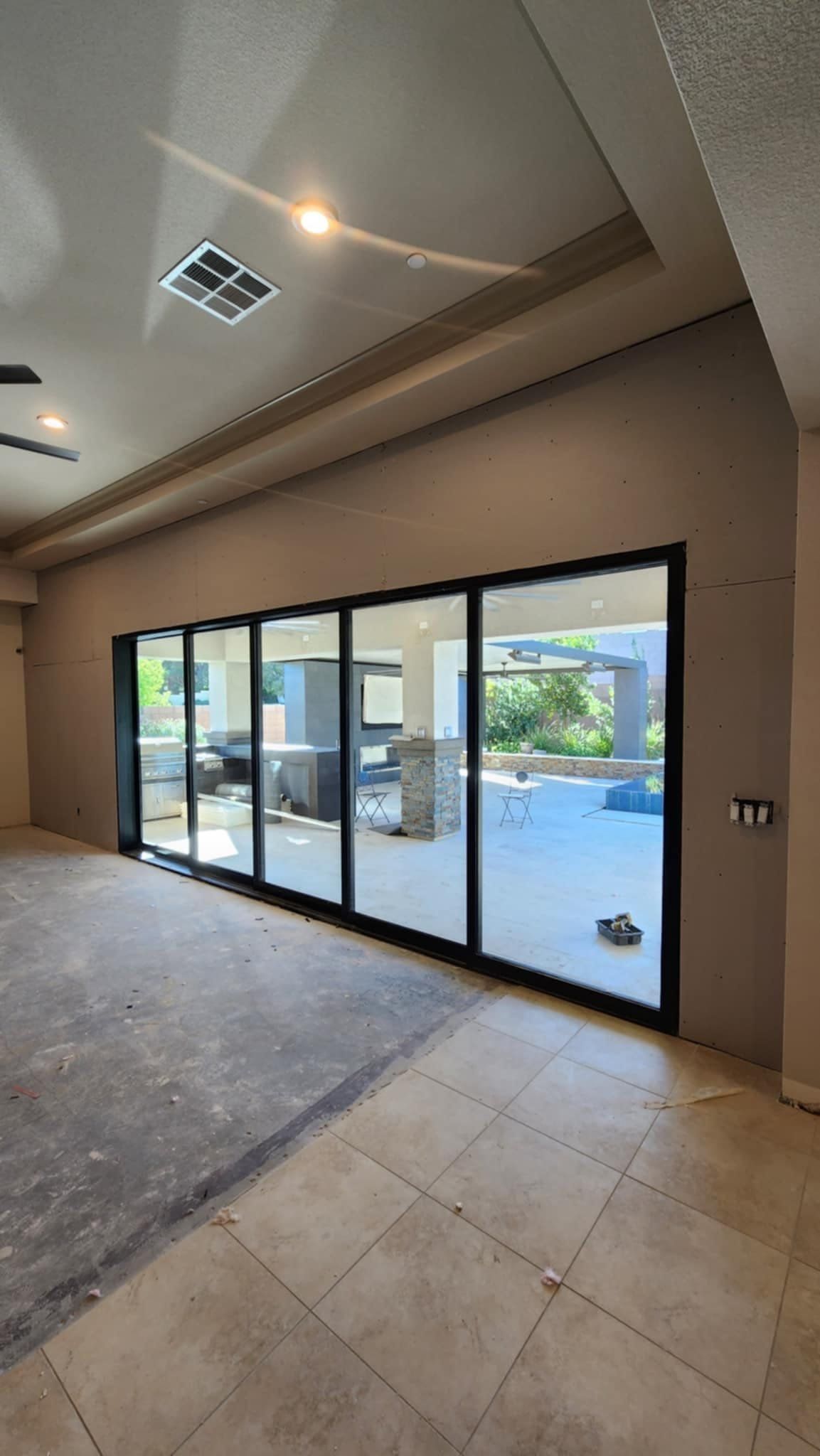A large room with a lot of windows and a ceiling fan.
