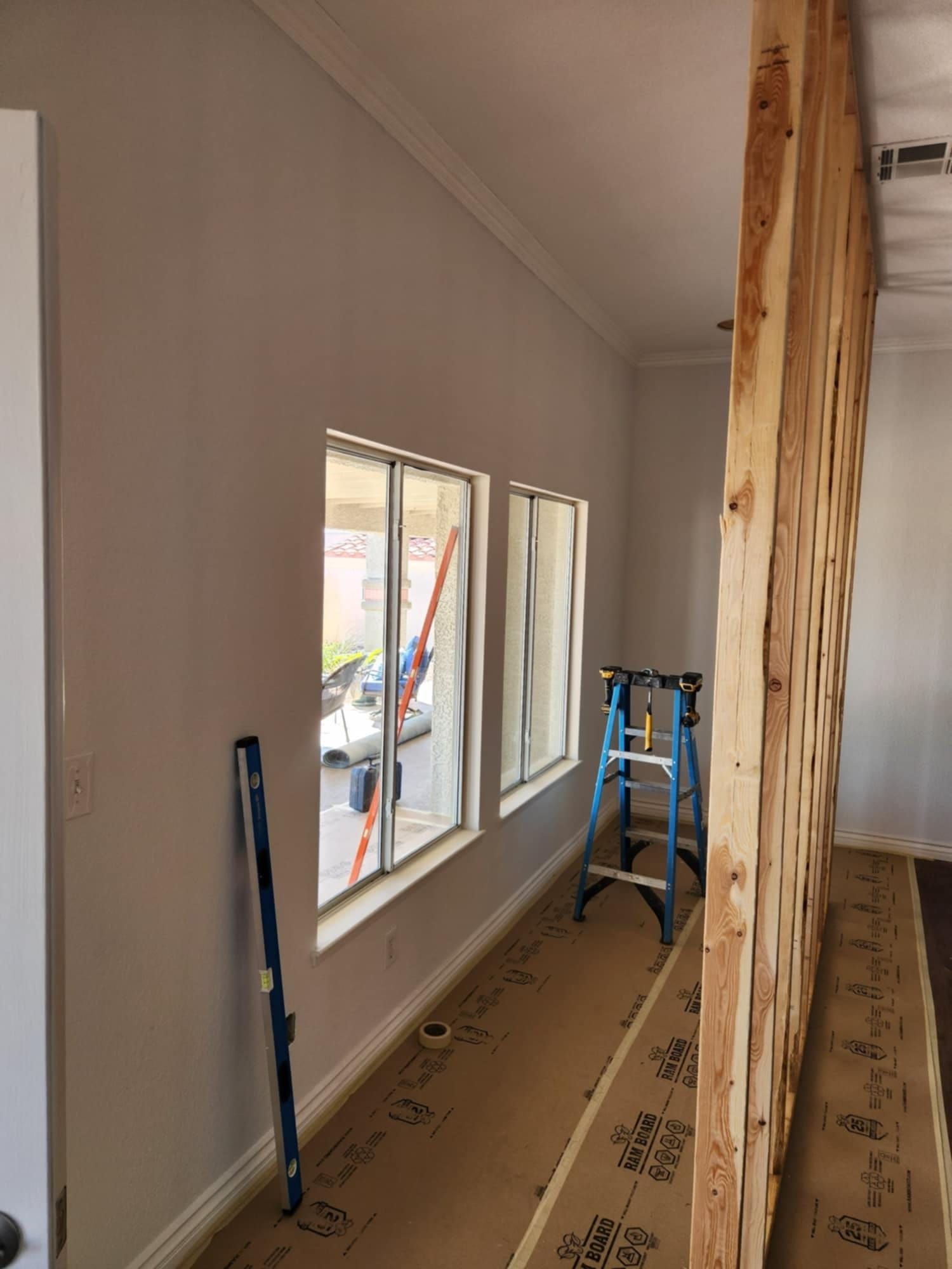 A room with a lot of windows and a ladder in it