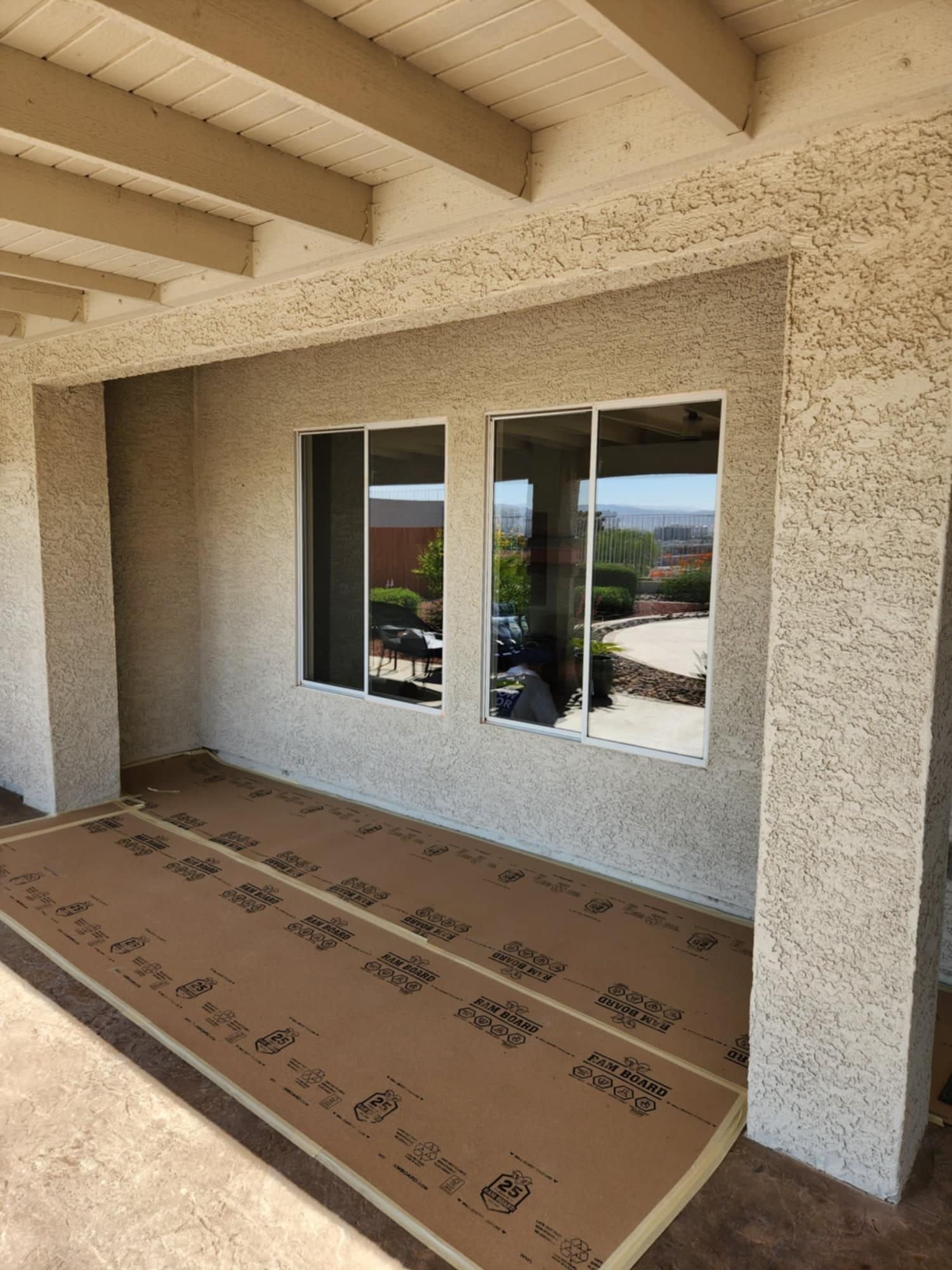 A patio with a lot of windows and a lot of cardboard on the ground.