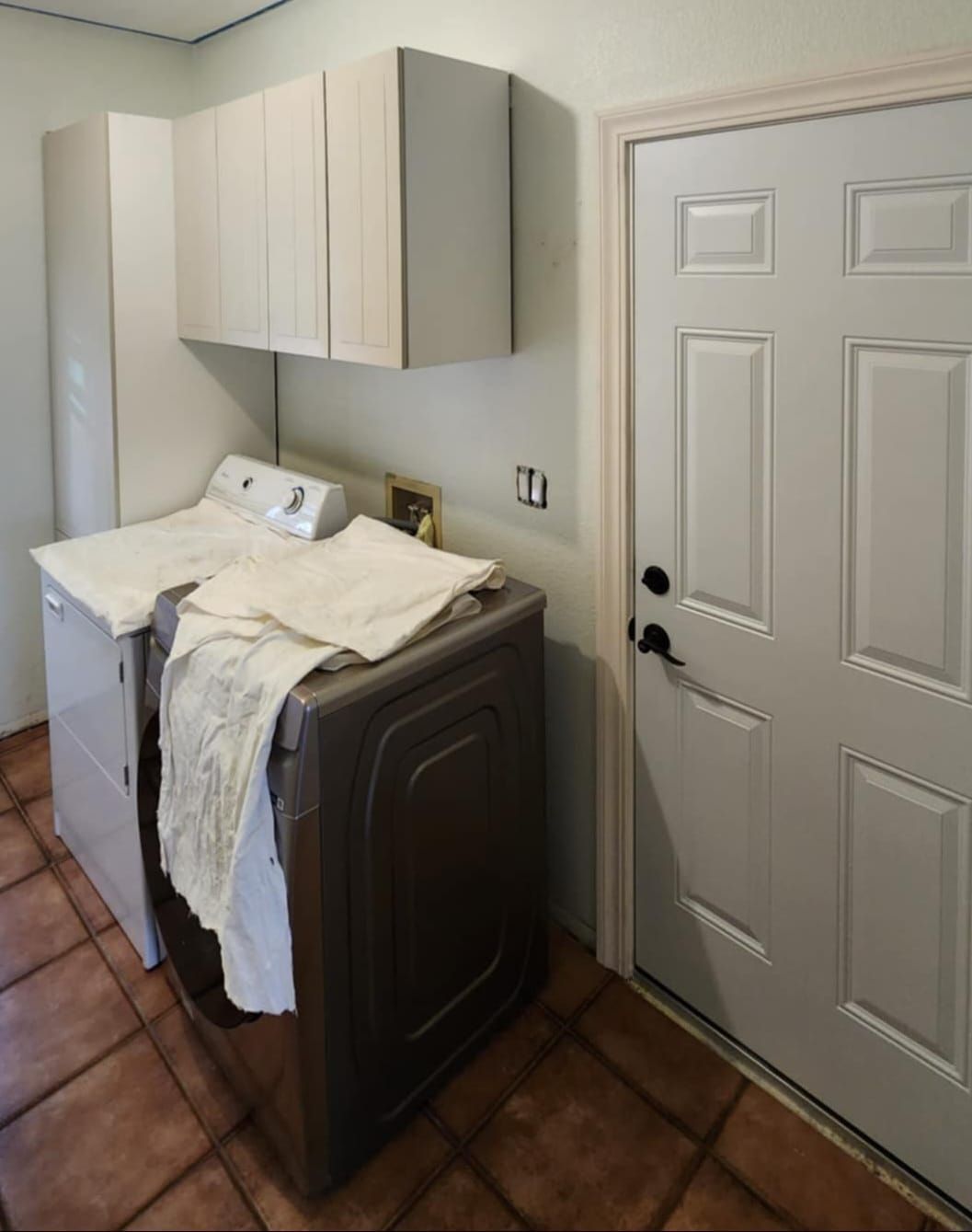 A laundry room with a washer and dryer and a door