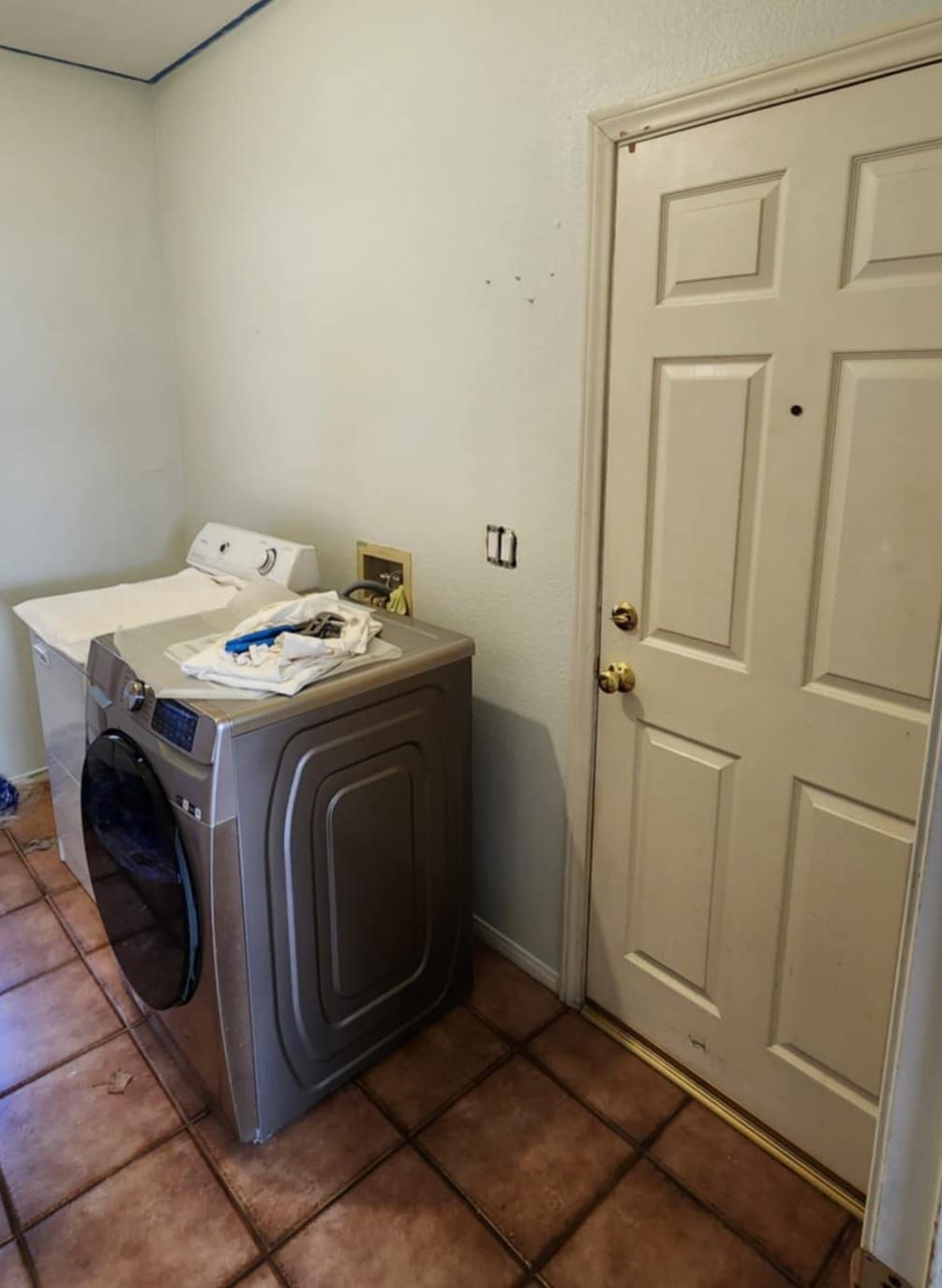 A laundry room with a washer and dryer next to a door.