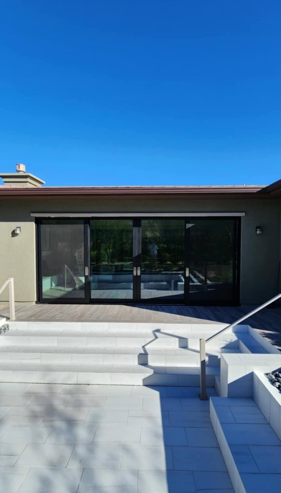 A house with a lot of windows and stairs leading up to it