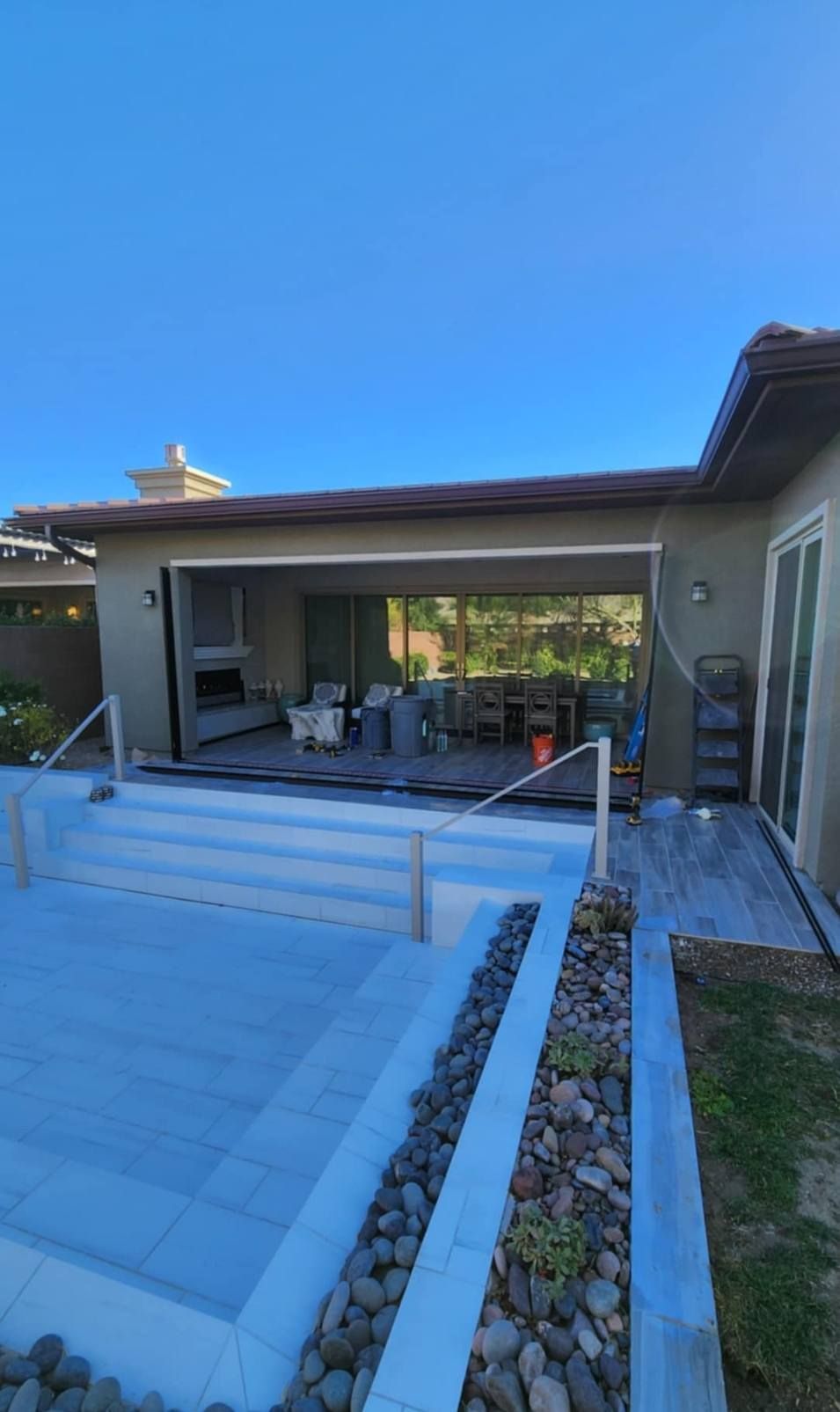 A house with a large sliding glass door leading to a pool.