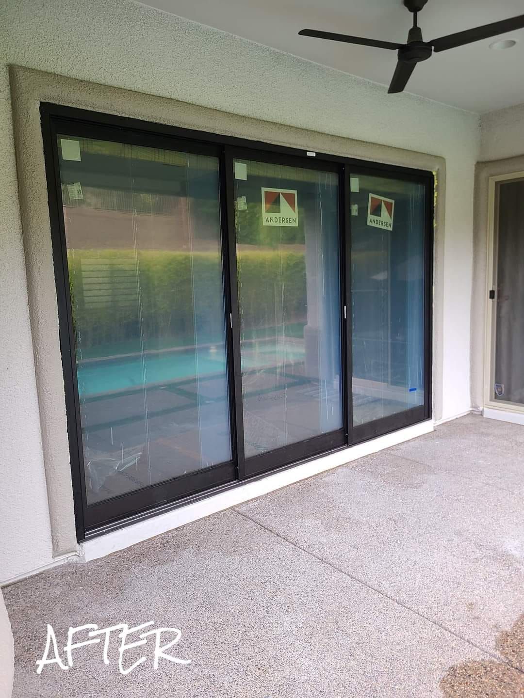 A patio with sliding glass doors and a ceiling fan.
