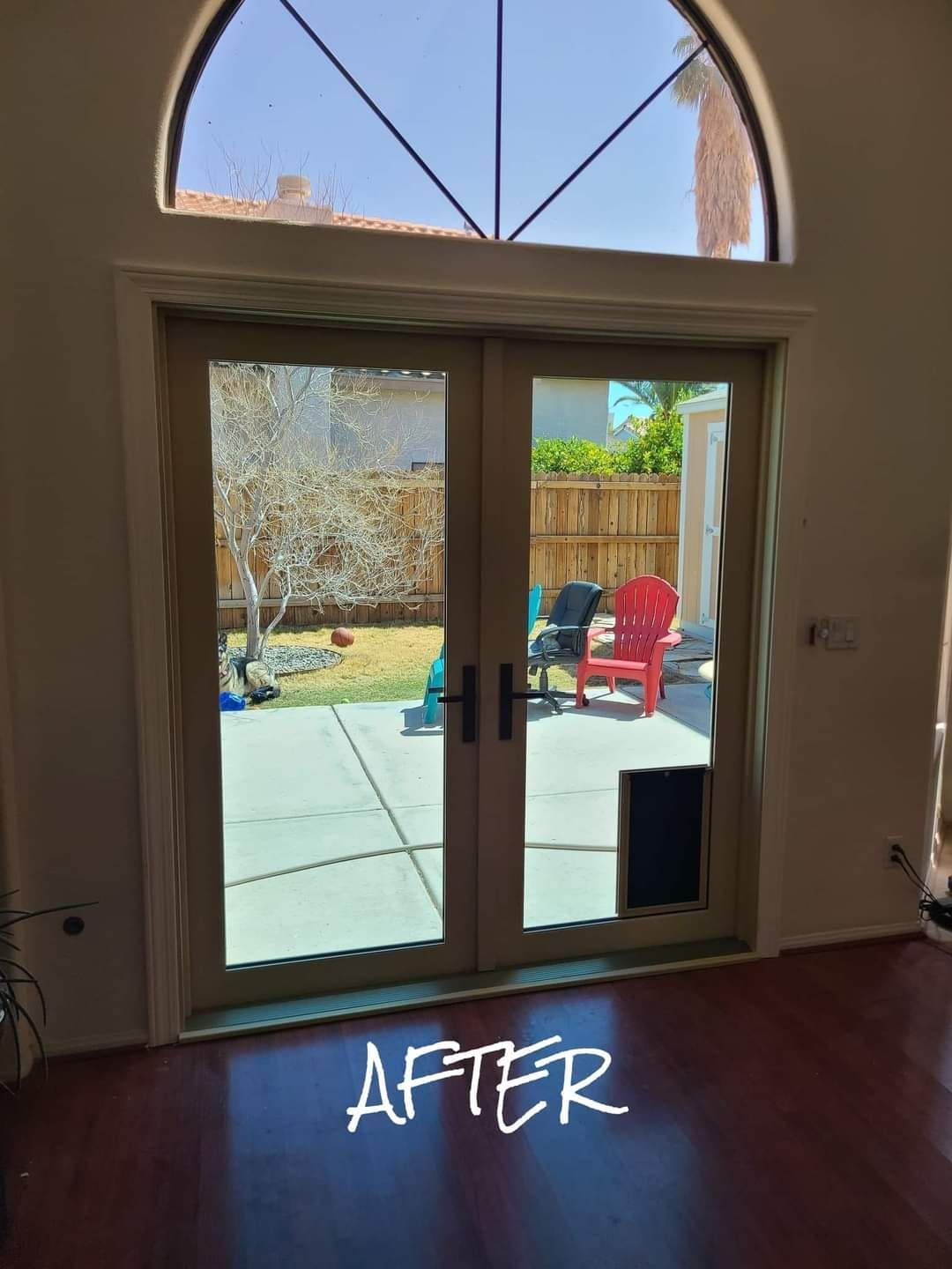 A picture of a living room with sliding glass doors and the words after written on the floor.