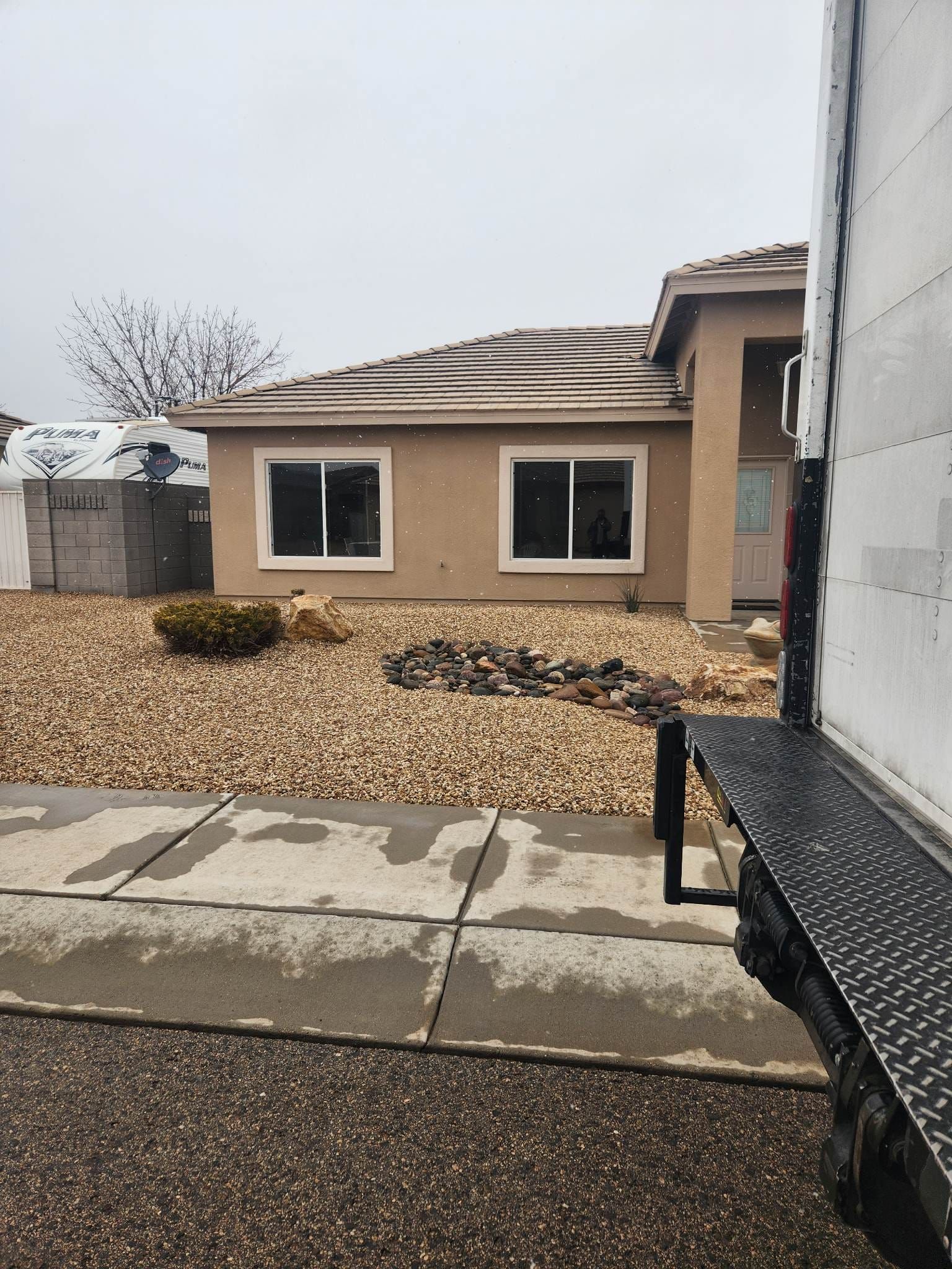 A moving truck is parked in front of a house.