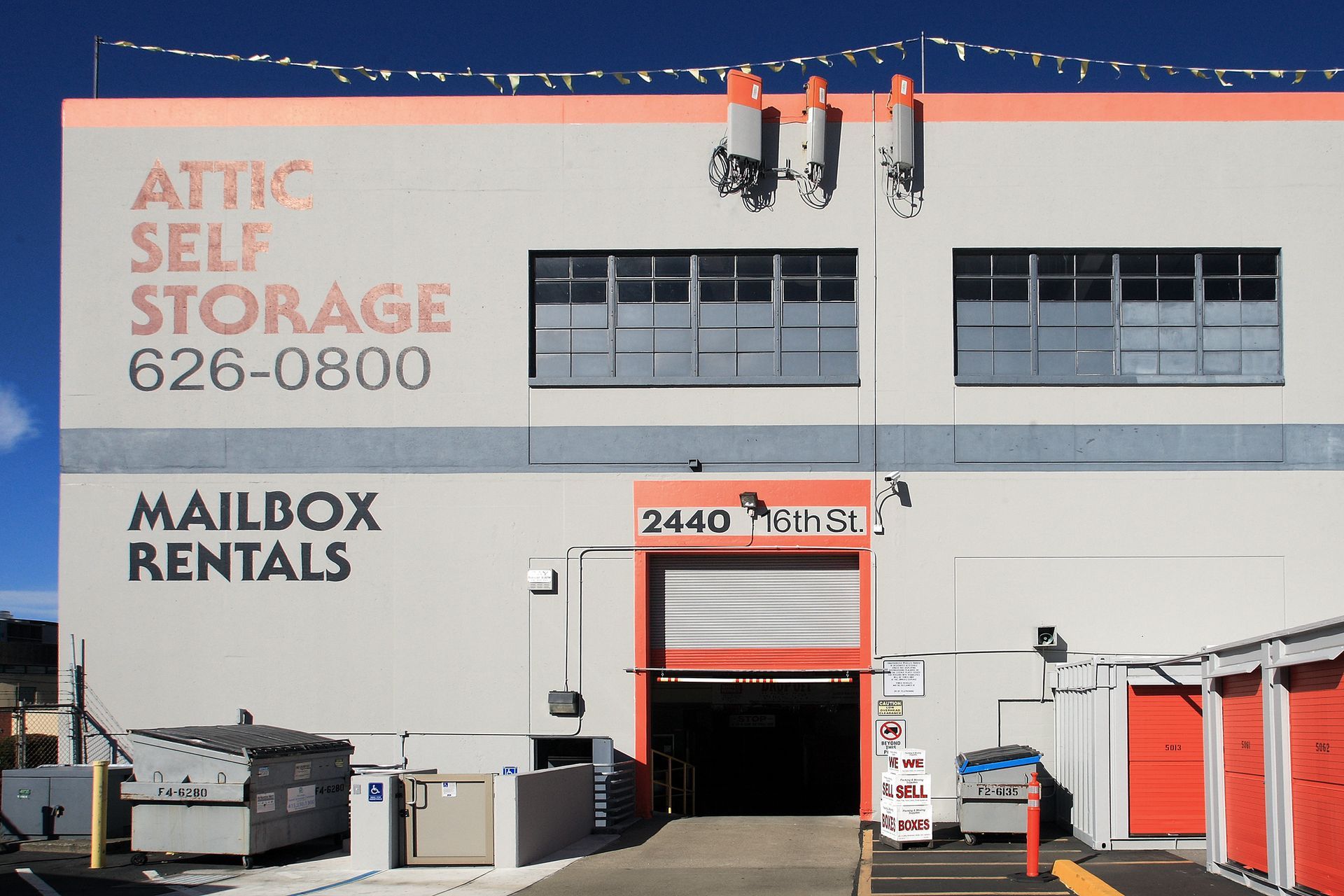 Attic Self Storage building with open entry, mailbox rentals, and orange and gray exterior.