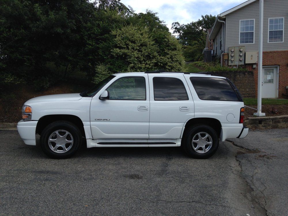 A white suv is parked in front of a house