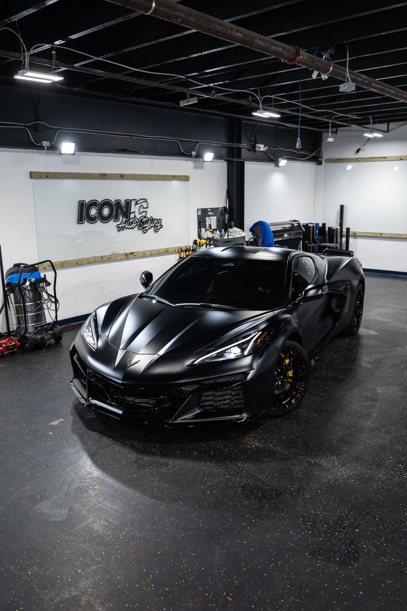 Matte black Ferrari with yellow emblem on the hood.