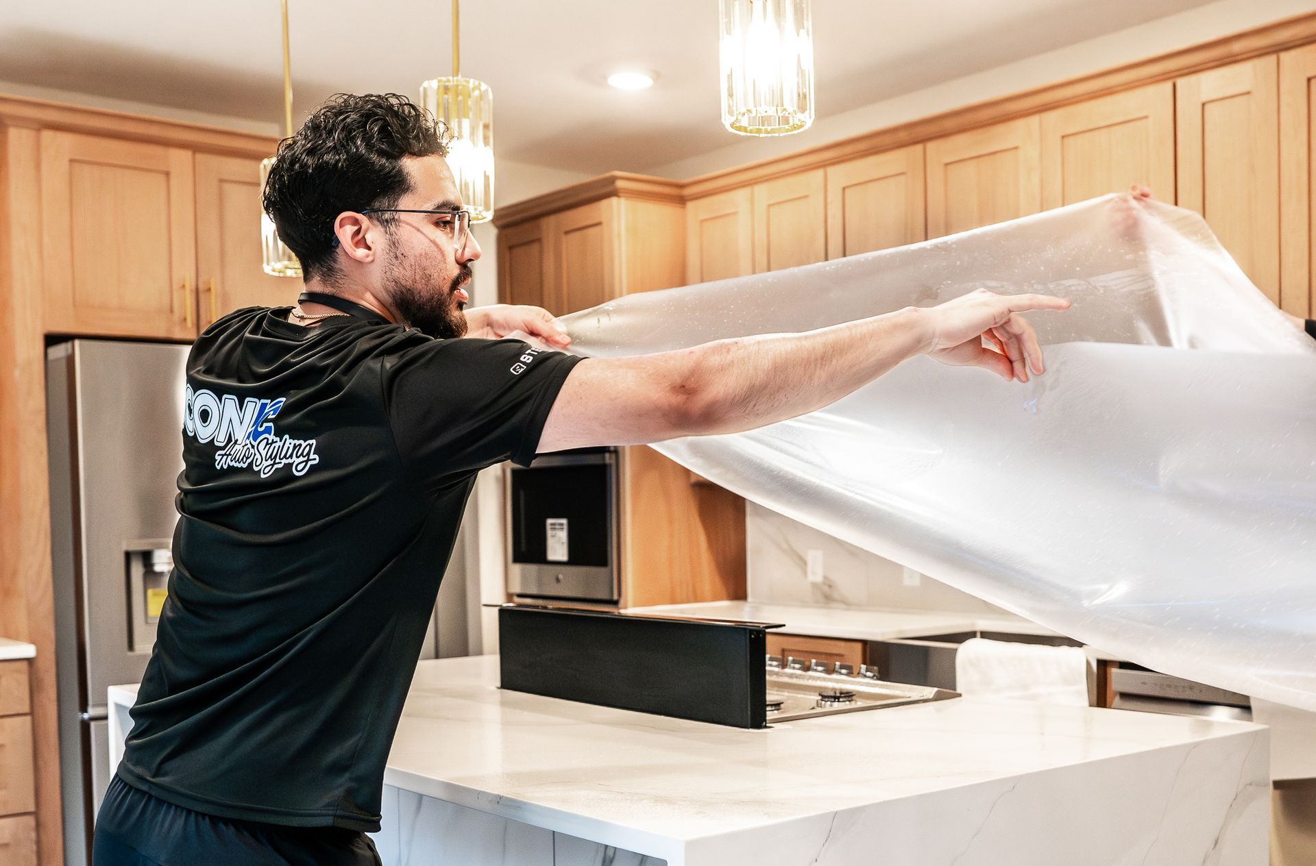 White kitchen with island, seating, and a dining table by a window.