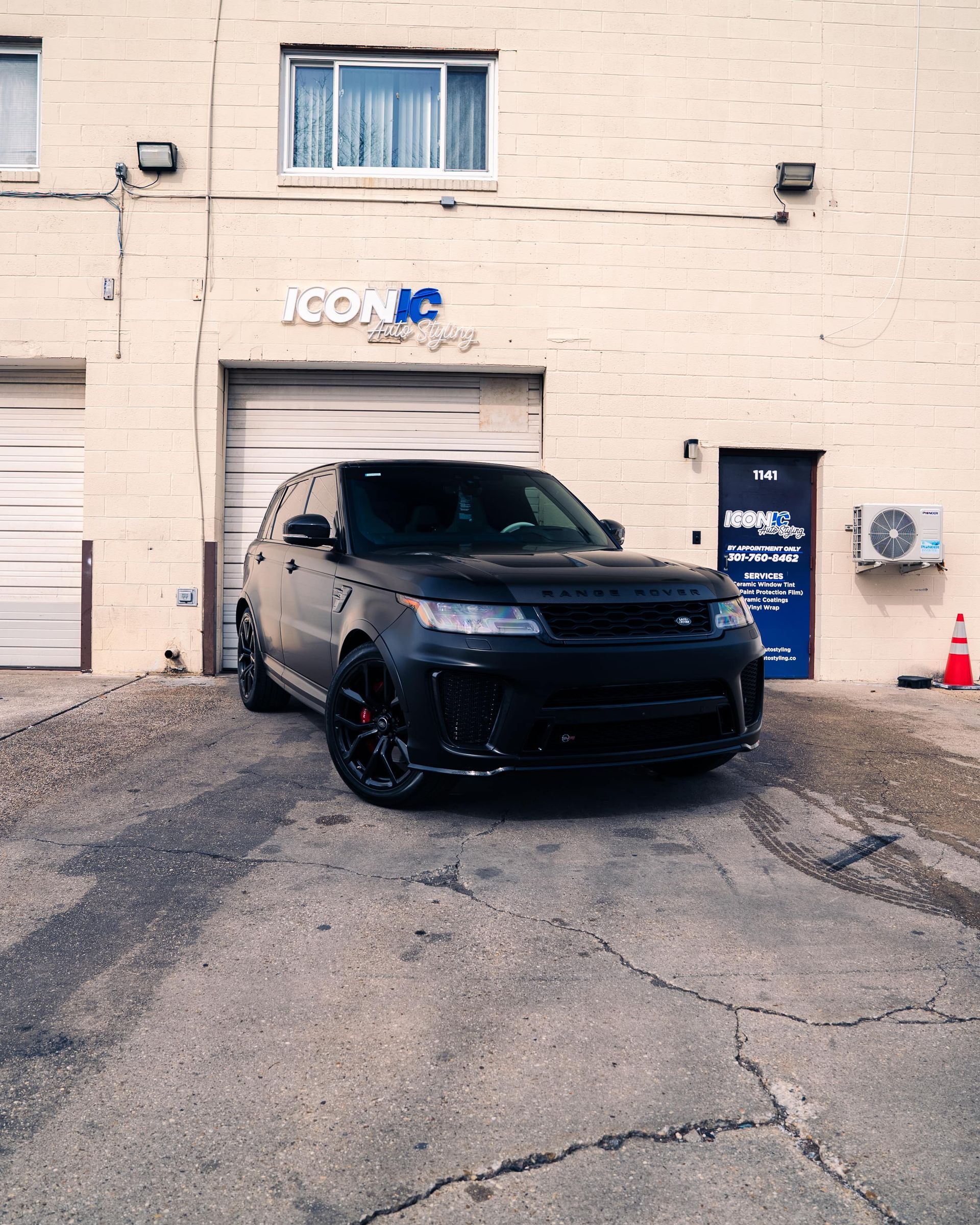 Black Range Rover Sport SUV parked outside a building with the name 
