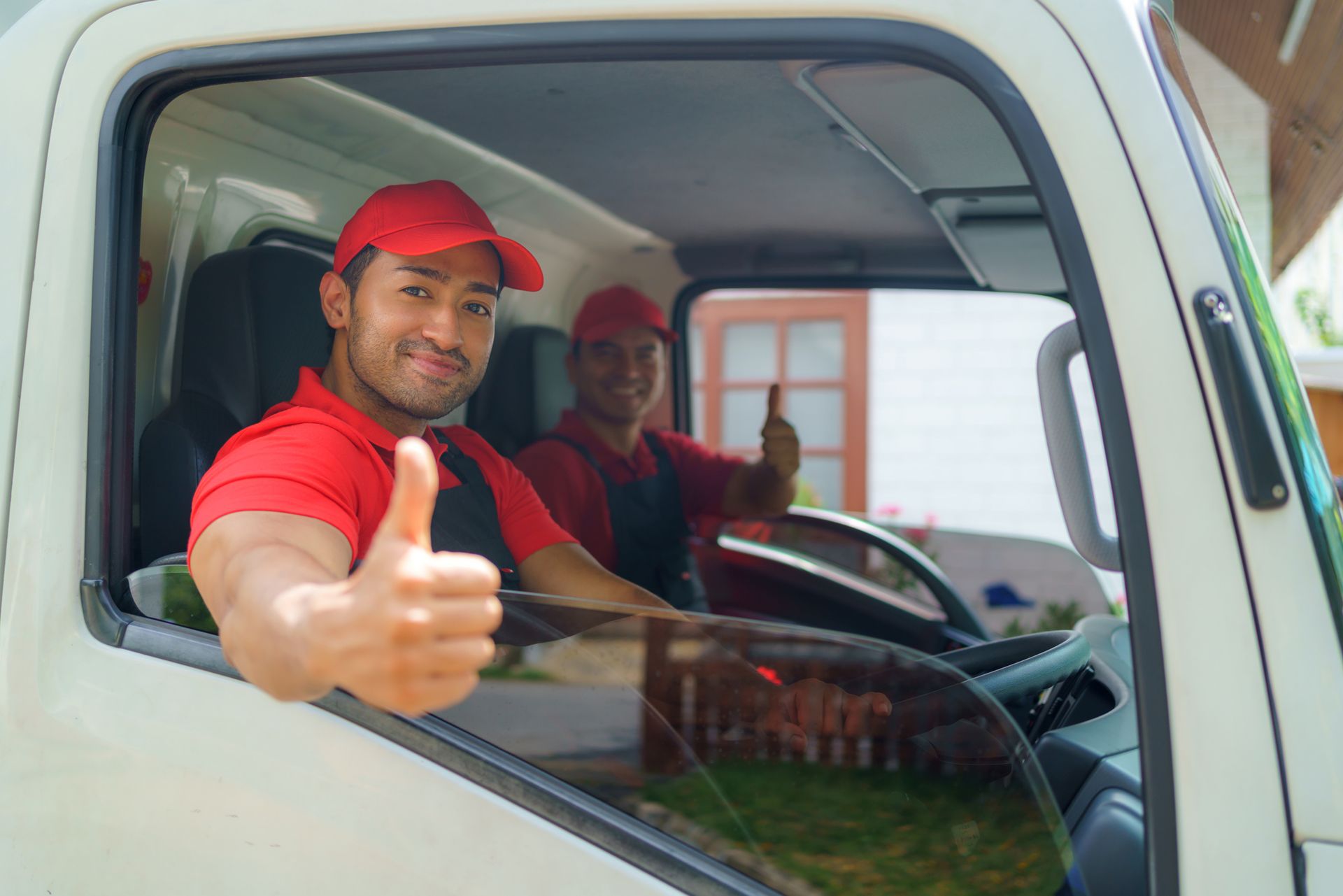 Transport workers sit in the cargo truck as they embark on the move to a new house.