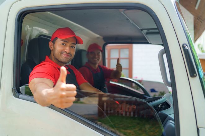 Transport workers sit in the cargo truck as they embark on the move to a new house. Transport workers sit in the cargo truck as they embark on the move to a new house.