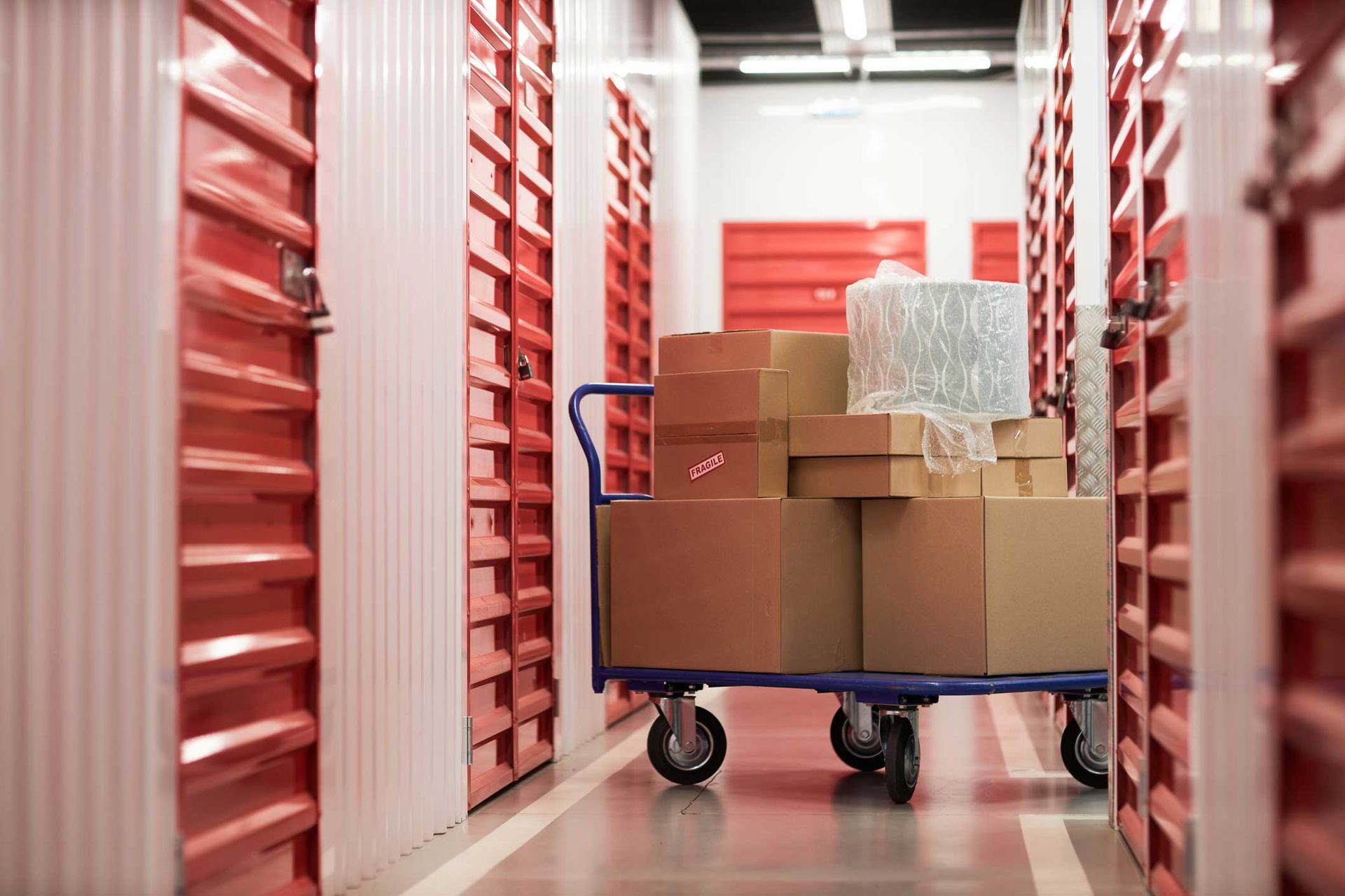 Cart with cardboard boxes in the corridor of self-storage.