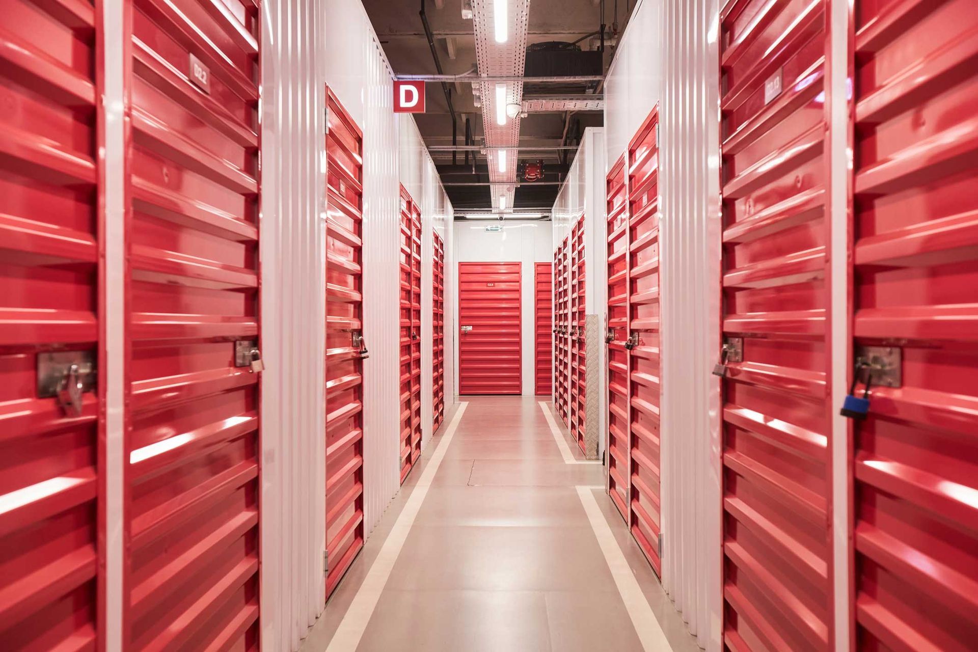 Locked red doors in the corridor of a self-storage facility.