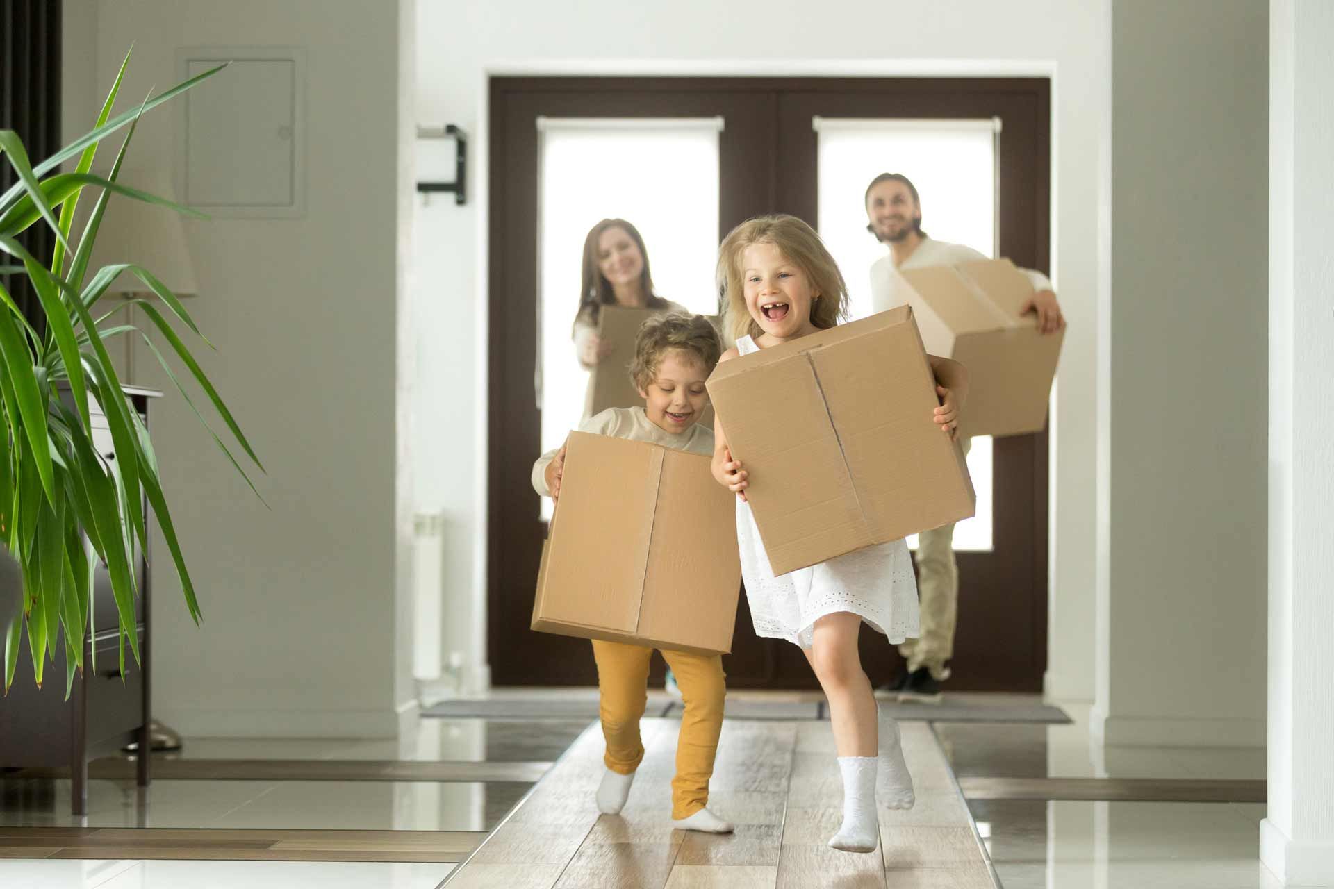 A family joyfully moving into a new home in Alpharetta, GA, surrounded by boxes. Jason Taylor Moving