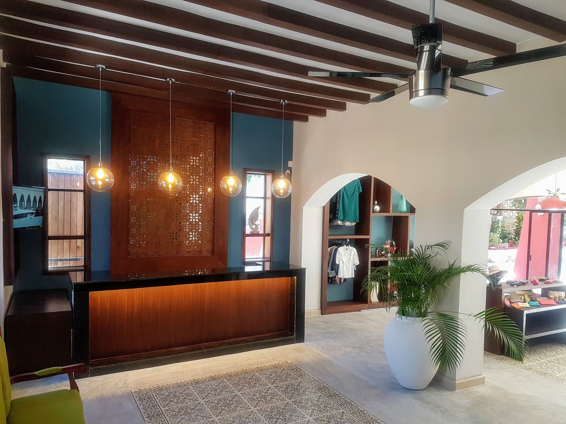 Un vestíbulo de hotel con un mostrador de recepción y un ventilador de techo.
