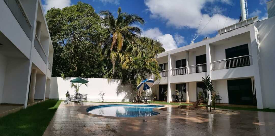 Un gran edificio blanco con una piscina delante.