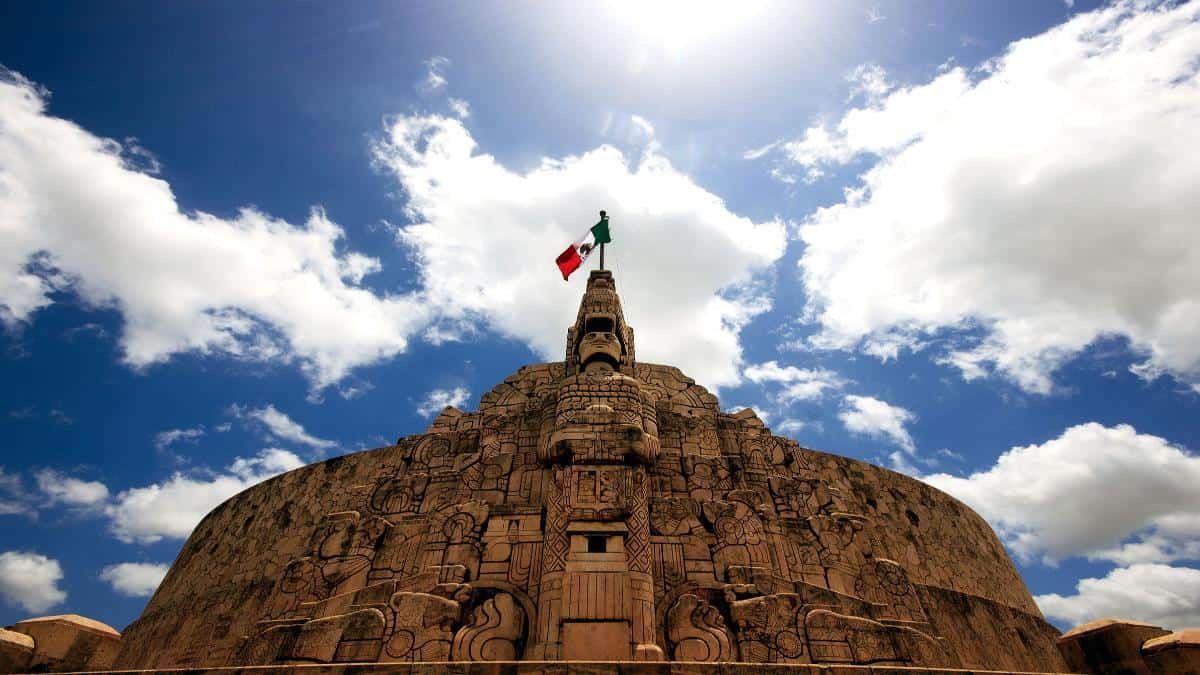 Una estatua con una bandera mexicana encima en Mérida