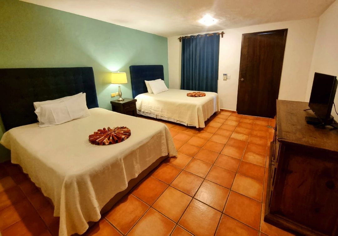 Una habitación de hotel con dos camas y televisión.