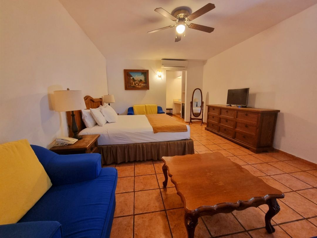 Una habitación de hotel con una cama tamaño king y un sofá azul.