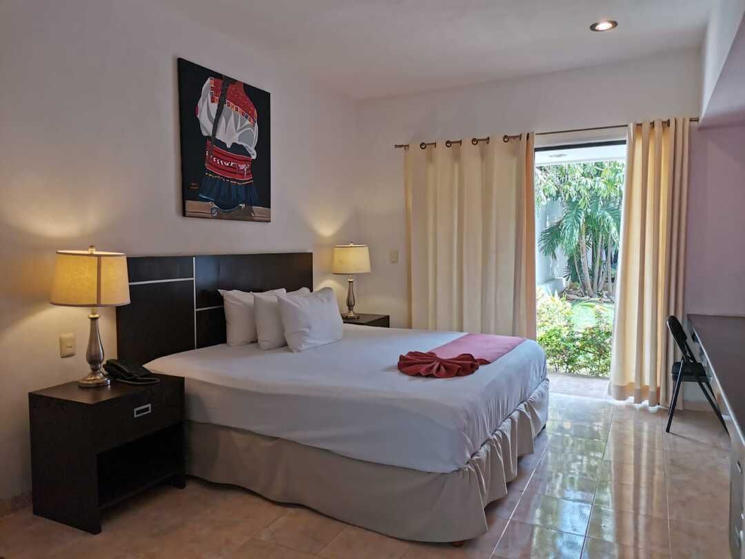 Una habitación de hotel con una cama tamaño king y un cuadro en la pared.