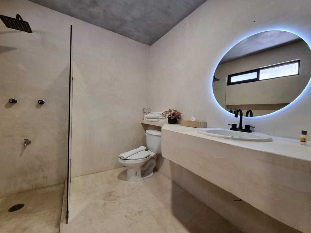 Un baño con inodoro, lavabo y ducha.