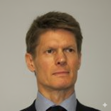 Man in a suit, looking forward with a neutral expression against a light grey background.