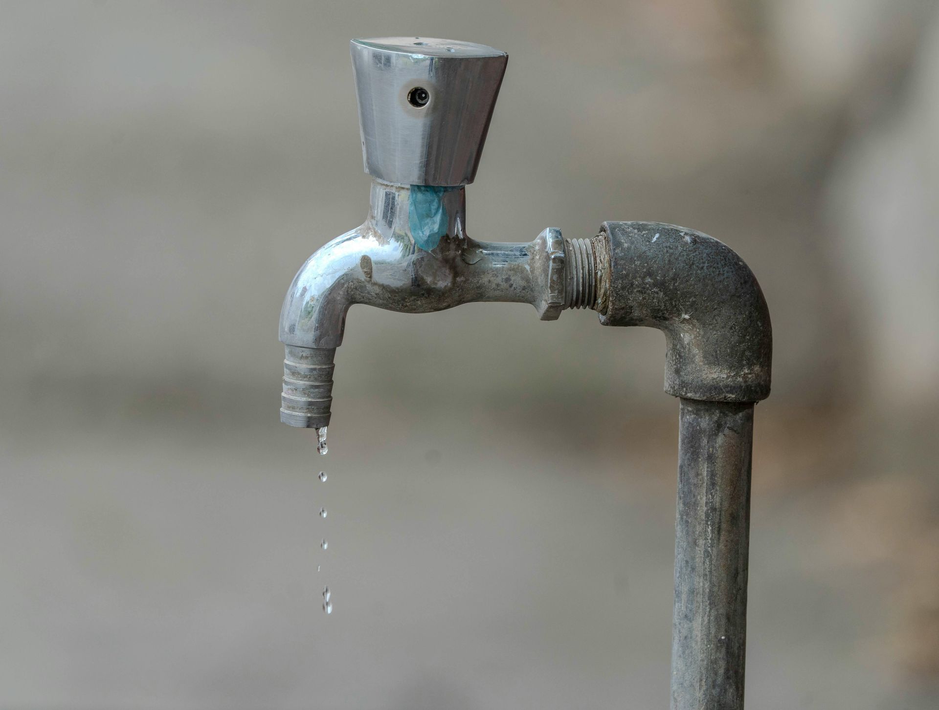 A close up of a faucet with water dripping from it.