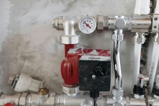 A close up of a heating system with a clock on it.