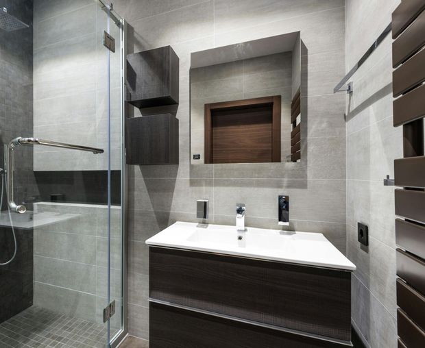 A bathroom with a sink a mirror and a walk in shower