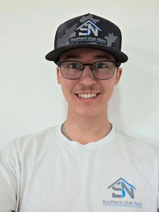 Person installing dark roof tiles on a house.