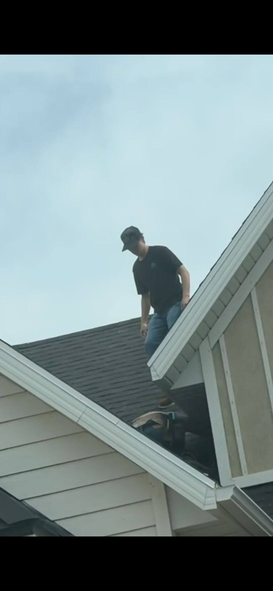 Woman in straw hat smiles, holding wine glass near a lake.
