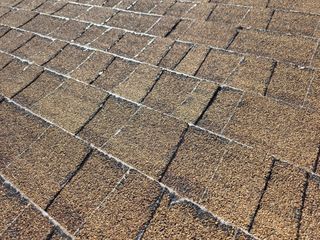 Brown asphalt shingles on a roof, angled close-up view.